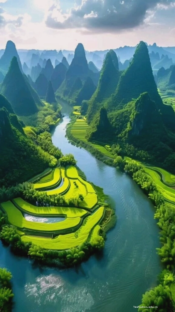 Con sông xanh ngọc chảy quanh núi đá hùng vĩ dưới bầu trời quang đãng