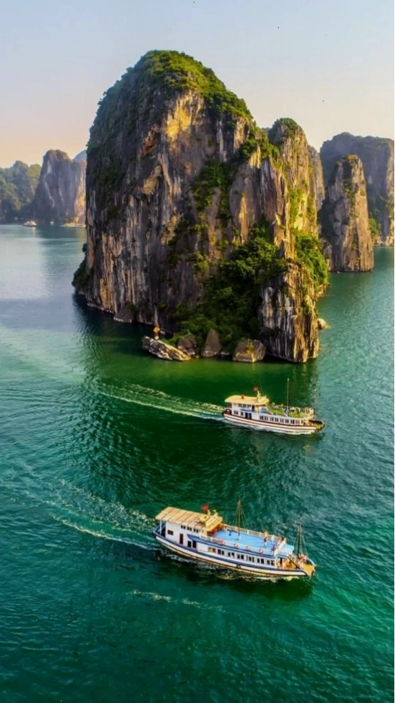 Du thuyền nhỏ giữa vịnh biển xanh và núi đá