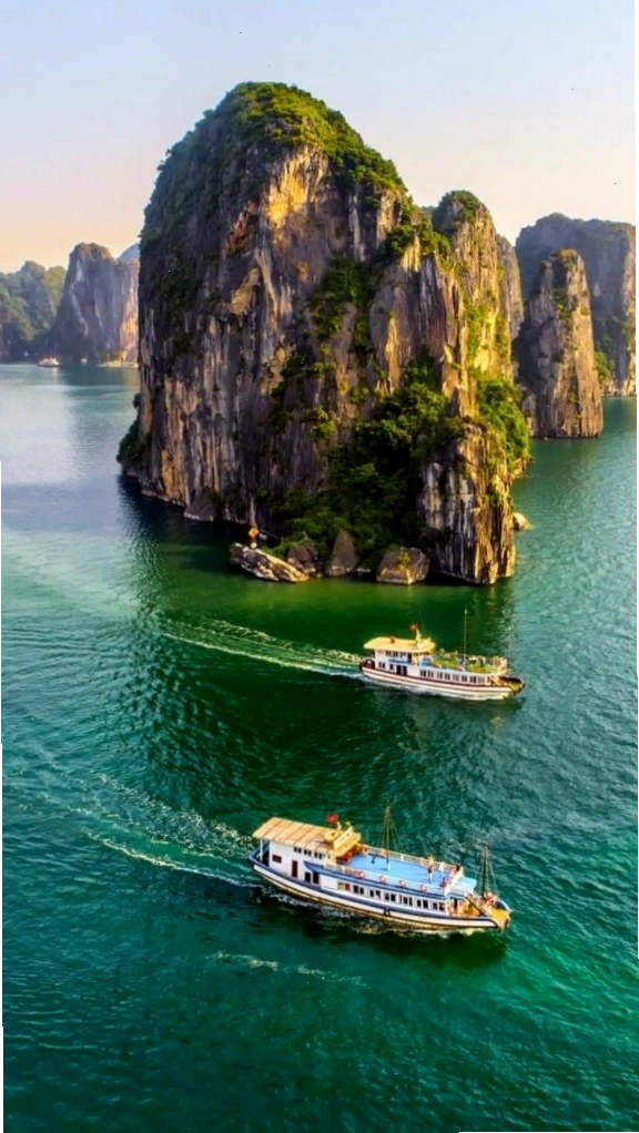 Du thuyền nhỏ giữa vịnh biển xanh và núi đá