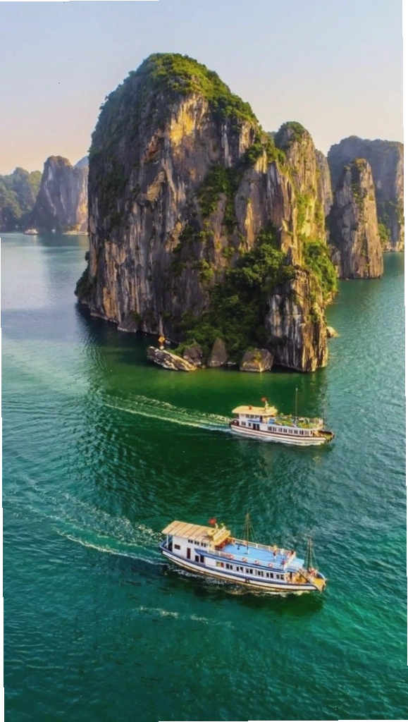 Du thuyền nhỏ giữa vịnh biển xanh và núi đá vôi hùng vĩ