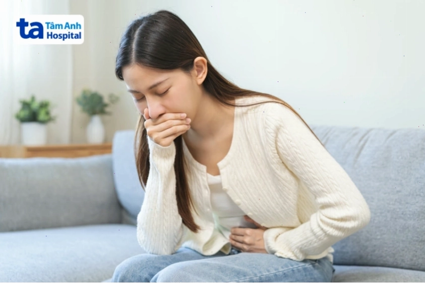 Người phụ nữ ôm bụng và buồn nôn, biểu hiện triệu chứng rối loạn tiêu hóa hoặc trào ngược.